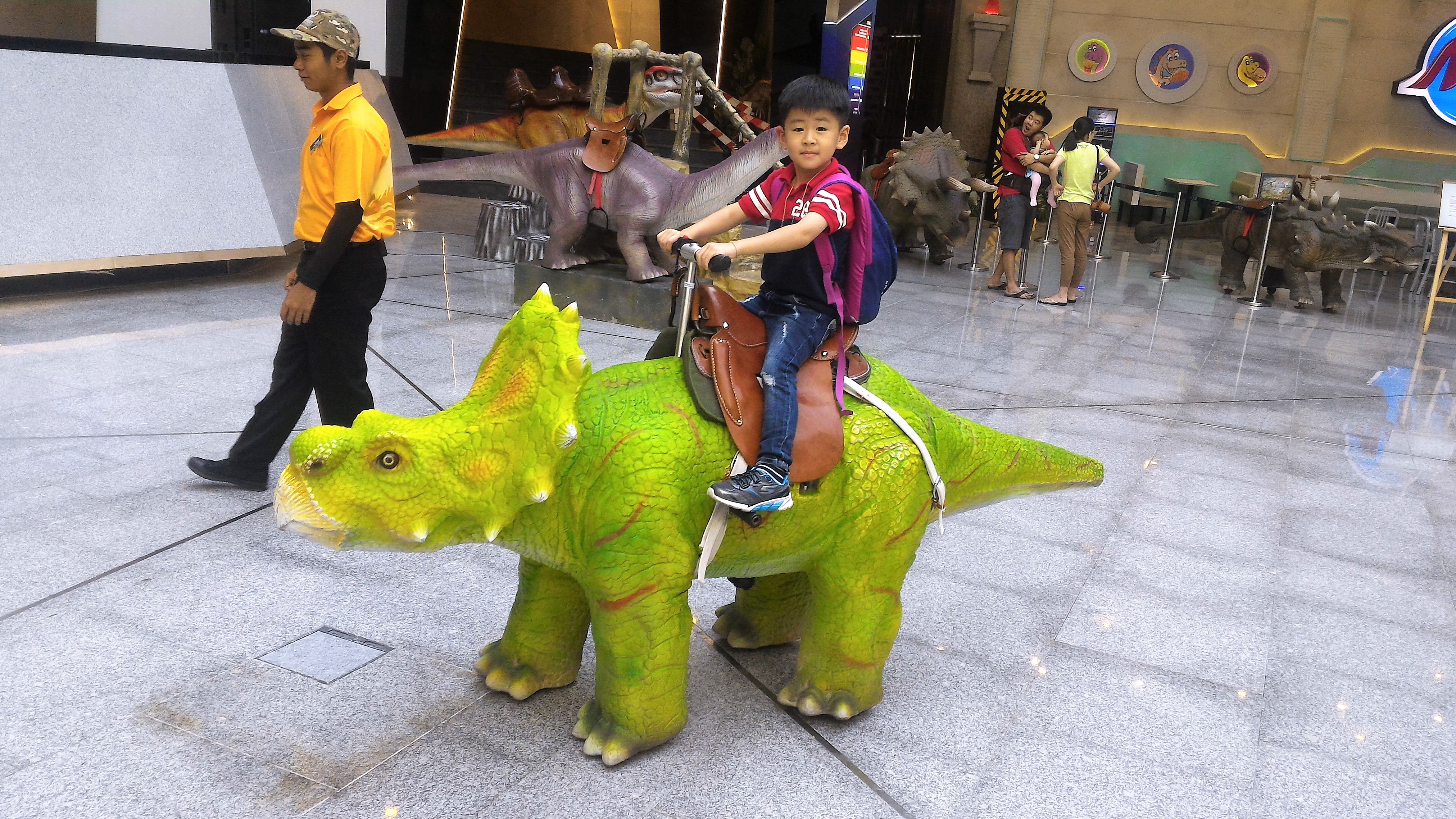 Rojak Daily/Yukeshwaran Devadas A little boy riding a dinosaur.